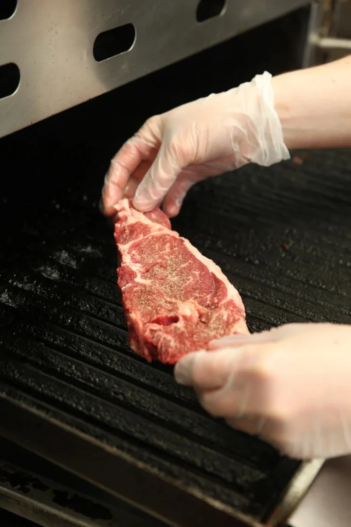 A steak being places on a stove